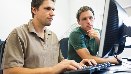 计算机室的教师和成熟学生人数桌子男性大学教育工作键盘互联网专注教学团队图片
