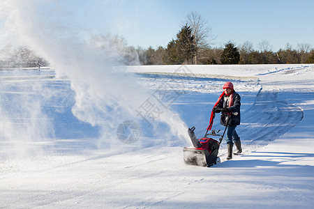 高级妇女与吹雪者清扫车暴风雪机器冷冻投掷者季节人行道车道女士天气机械图片