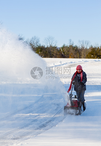 高级妇女与吹雪者清扫车驾驶人行道降雪车道女士工作打扫机械天气暴风雪图片