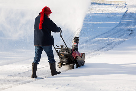 高级妇女与吹雪者清扫车住宅季节冷冻鼓风机暴风雪投掷者人行道机器退休机械图片
