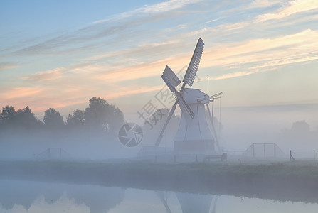 日出时清晨雾中荷兰风车图片