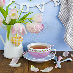 茶叶和新鲜郁金香蛋糕正方形勺子盘子杯子咖啡时间粉色骨瓷生日图片