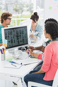 在创意办公室办公桌工作的艺术家电脑设计师桌子专注技术职场职业女性便服电脑显示器图片