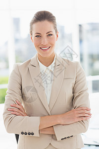 一个年轻女商务人士的肖像 带着双臂穿过微笑图片