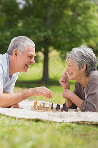 快乐的老夫妇在公园下棋树木乐趣夫妻地毯短发享受幸福女性农村退休图片