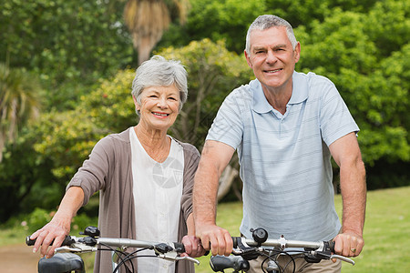 在公园骑自行车的老年夫妇享受成人锻炼女士退休女性夫妻人员灰色男人图片