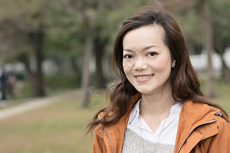 在公园中微笑的亚裔年轻女子快乐魅力上诉喜悦女士女性乐趣图片