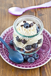 配有新鲜蓝莓的多层甜点餐巾勺子奶油琐事巧克力奶油状果味冰冻浆果盘子图片