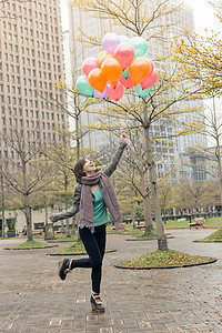 快乐笑笑的亚洲女人拿着气球快乐魅力女士女性公园乐趣微笑图片