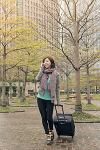 街头旅行妇女游客女性行李手机手提箱电话乘客公园女士技术背景图片