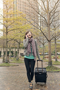 街头旅行妇女游客手提箱女性微笑公园技术女士乘客电话行李背景图片