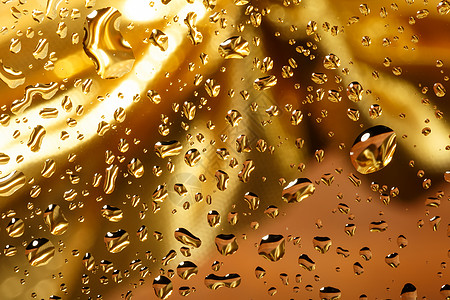 带有水滴的金色抽象背景金属玻璃宏观气泡雨滴液体珠子飞沫黄色艺术图片