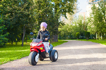 在绿公园骑自行车的小可爱女孩儿图片