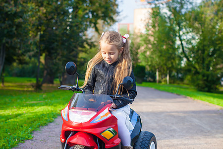 可爱的小女孩骑着玩具摩托车情感运输喜悦女孩乐趣童年运动孩子微笑引擎图片