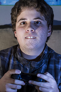 在家里玩电脑游戏的男孩儿 拿着拐杖青少年闲暇技术青年享受电脑微笑童年控制器男人图片