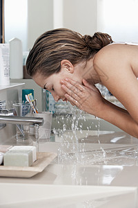 在浴室洗脸的女子成人茶点龙头反射护理女士露肩飞溅健康美丽背景图片
