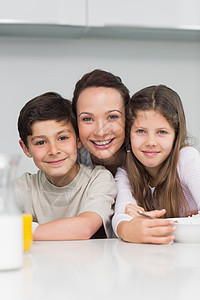 一个微笑的母亲和孩子们在厨房里 的紧贴镜头图片