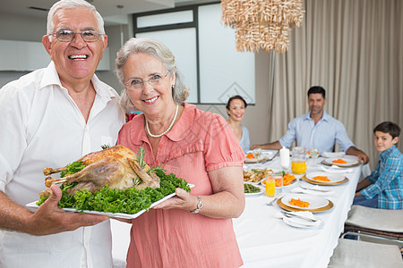 祖父母在餐桌上与家人一起吃烤鸡肉童年男生孙辈盘子午餐桌子晚餐老年家庭生活儿子图片