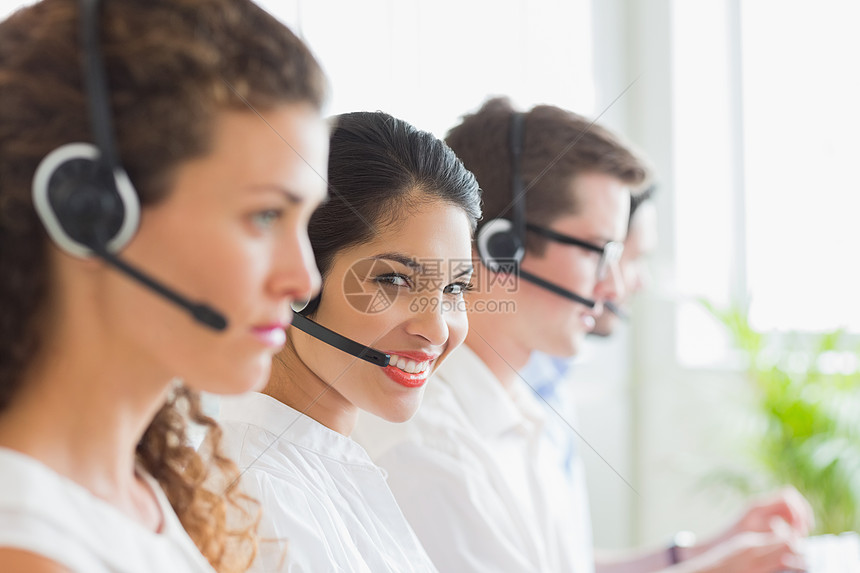 在呼叫中心工作的微笑的女商业妇女职业团结办公室混血男性生意人合作职场人士耳机图片