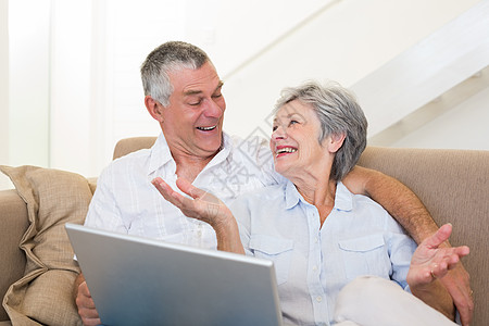 在沙发上用笔记本电脑爱老夫妇背景图片