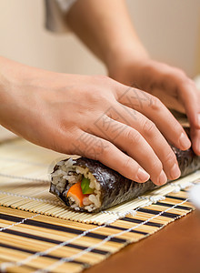 女厨师的手卷起日本寿司餐厅饮食食物女士竹子美食海苔海鲜床单大豆背景图片