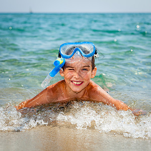 男孩在海滩上活动游泳衣齿轮娱乐童年潜水乐趣蓝色喜悦面具图片