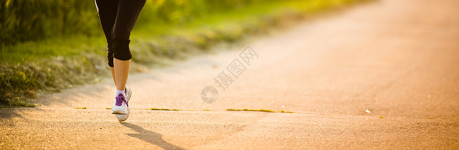 一名女性选手在路上的腿树木城市赛跑者成人运动装活力运动慢跑者女孩娱乐背景图片