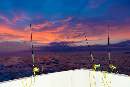 日落时用棍棒和鱼钓渔船波浪卷轴橙子盐水天空钓鱼血管反射游戏海洋图片