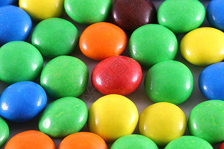 色彩多彩的糖果小吃涂层巧克力橙子蜜饯纽扣形味道按钮店铺墙纸背景图片