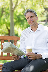 手持一次性杯子和公园报纸的商务人士衬衫长椅商业绿地咖啡商务成人人士饮料空闲图片