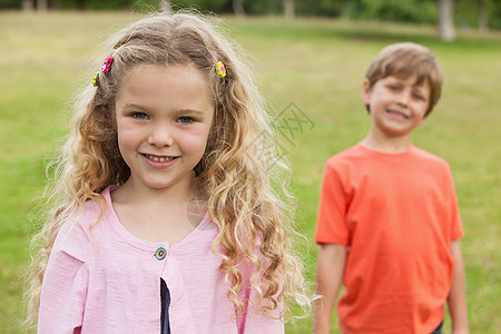 两个微笑的孩子 站在公园里图片