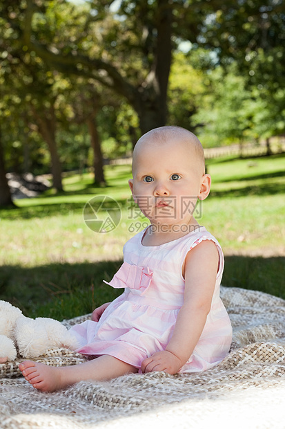 坐在公园毯子上的可爱婴儿绿地树木婴儿期服装闲暇女婴女孩女性草地童年图片