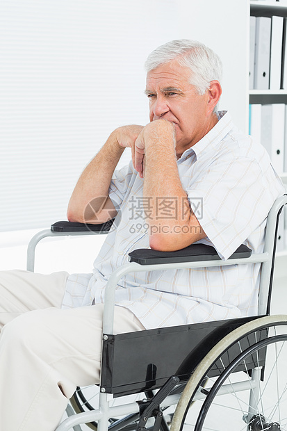 坐在轮椅上的一位悲伤的老年男子的侧面观保健机动性成人人员身体退休残疾人医务室医院沉思图片