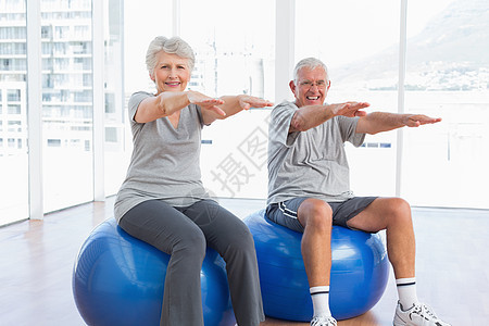 老年夫妇在健身球上做伸展锻炼女士身体治愈女性男人男性拉伸成人退休病人图片