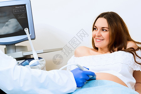 接受医生诊治的怀孕妇女婴儿成人女士儿科考试诊所卫生微笑待产检查图片