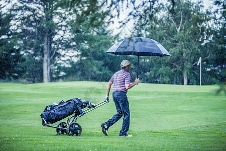高尔夫伞高尔夫球场在雨天时结束忧郁下雨辞职高尔夫球俱乐部球道阵雨淋浴预报退休背景