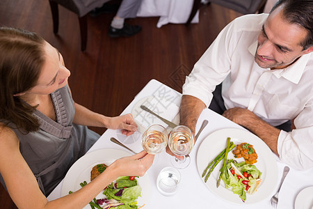 在餐厅餐桌边烤红酒杯的一对夫妇女士玻璃友谊享受闲暇朋友们桌子食物庆典成人图片