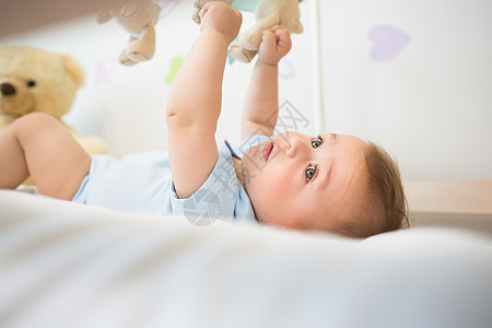 躺在婴儿床的婴儿宝宝男孩玩手机游戏男性男生住所新生活双手毯子服装蓝色手指公寓图片