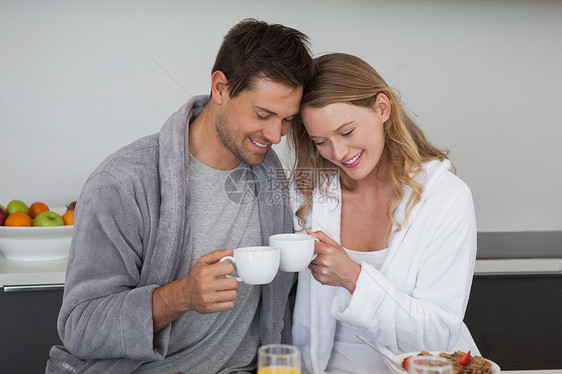 在厨房有咖啡杯的年轻夫妇亲密感夫妻女性浴衣男人男性女士家庭生活早餐亲热图片