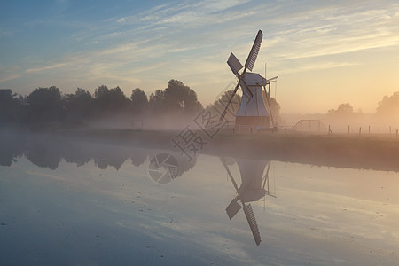 清晨阳光下的风车 在河中照耀图片
