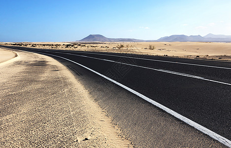 穿过沙漠的路蓝色车道沥青干旱小路运输地平线旅行晴天火山图片