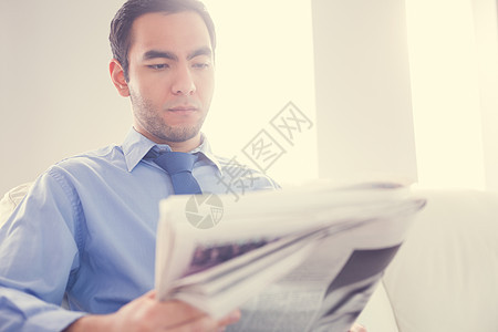 认真的英俊帅气商务人士阅读报纸棕色的头发高清图片素材
