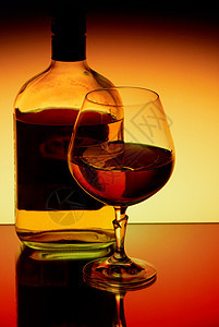 在明亮的背景中饮烈酒瓶子工作室球杯酒精红色液体橙子玻璃黄色黑色图片