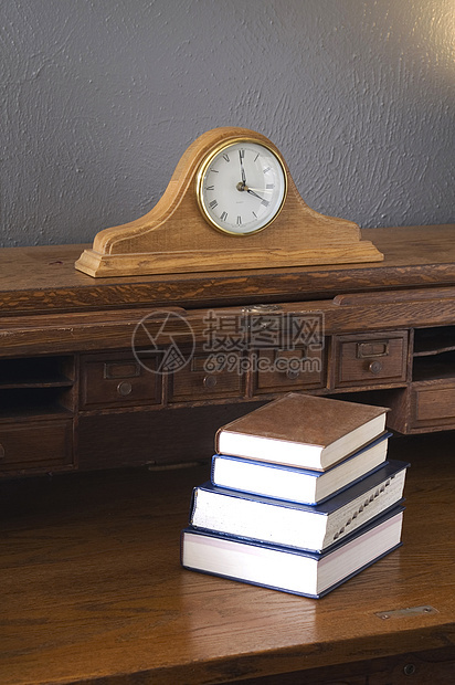 古老的挂着曼托时钟的滚式书桌图片