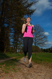 妇女慢跑衬衫太阳跑步慢跑者训练森林金发女郎碎石运动员踪迹图片