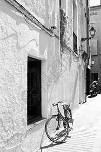白墙上的自行车街道白色孤独石头场景晴天阴影运输照片黑色图片