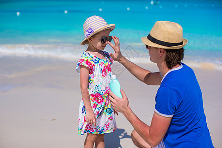 父亲在他女儿鼻子上涂防晒霜膏孩子家庭海滩男人护理喜悦棕褐色紫外线奶油海洋图片