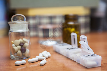 和平日旧药瓶和几颗药丸放在木制桌子上药片胶囊保险箱案件治疗药店药物组织药盒剂量背景