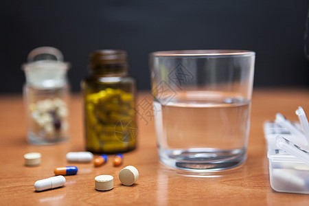 和平日旧药瓶和几颗药丸放在木制桌子上药片日历副作用药店案件保险箱日程药物胶囊剂量背景