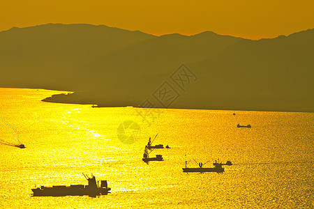 海中日落时散装货船反射海景日出日落油船商业船运天空出口海岸线图片